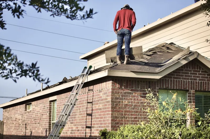 Professional roofer working on a residential roof in Kenwood